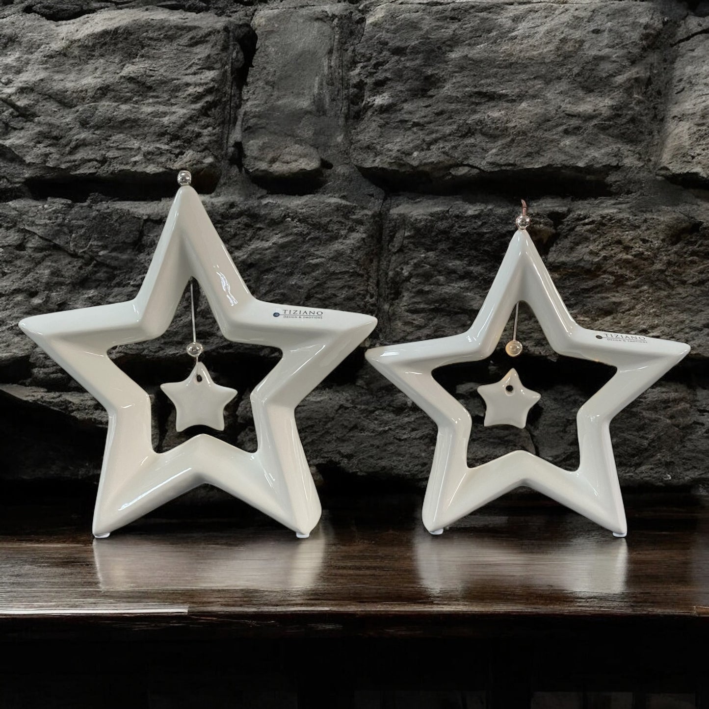 Zwei creme-weiße Keramik Sterne Saphira mit kleinem hängenden Stern in der Mitte im Ambiente