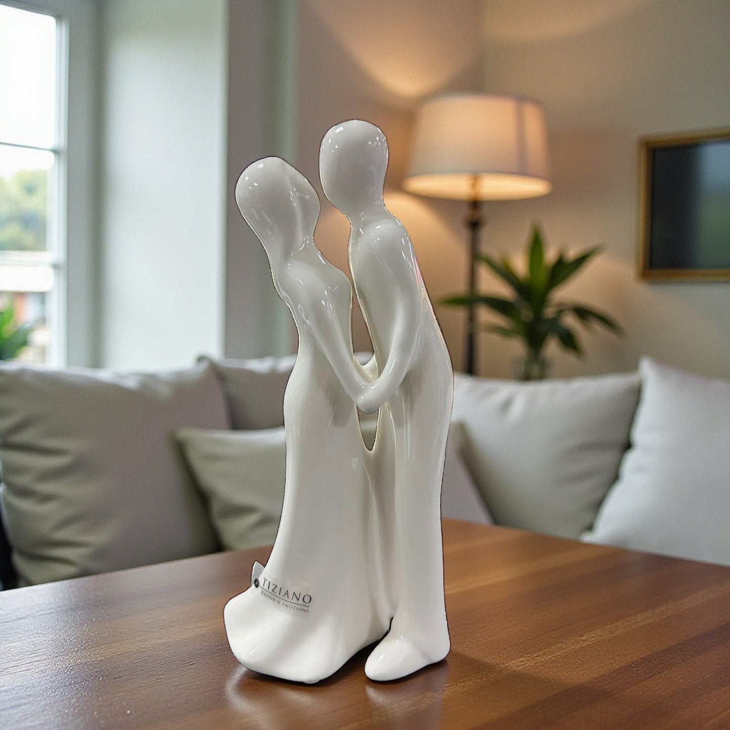 Weiße Keramik Dekofigur Paar Hand in Hand auf Holztisch im Wohnraum