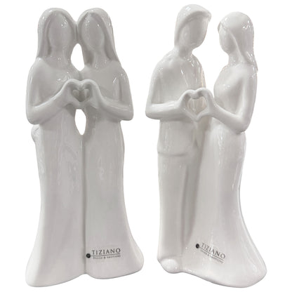 Zwei weiße Keramikfigurenpaare mit geformtem Herz aus den Händen vor weißem Hintergrund