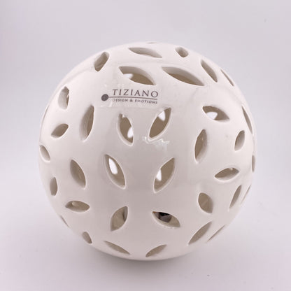 Eine große Dekokugel aus creme-weißer Keramik, die von innen mit einem LED Licht beleuchtet werden kann. Sie hat ovalförmige Aussparungen. Die Kugel 12cm groß und vor weißem Hintergrund platziert.