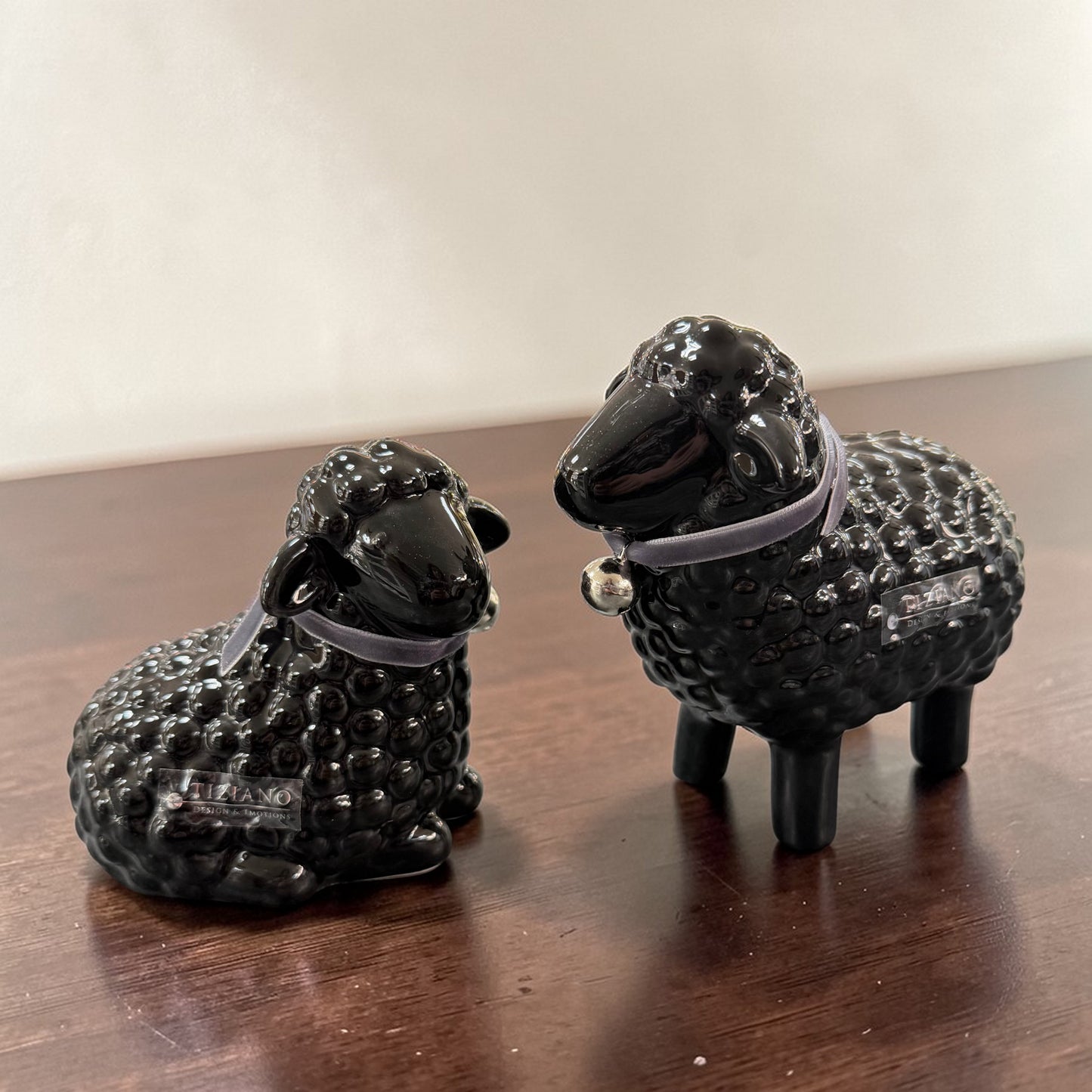 Schwarze Keramik-Schaffiguren liegend und stehend mit Halsband auf Tisch