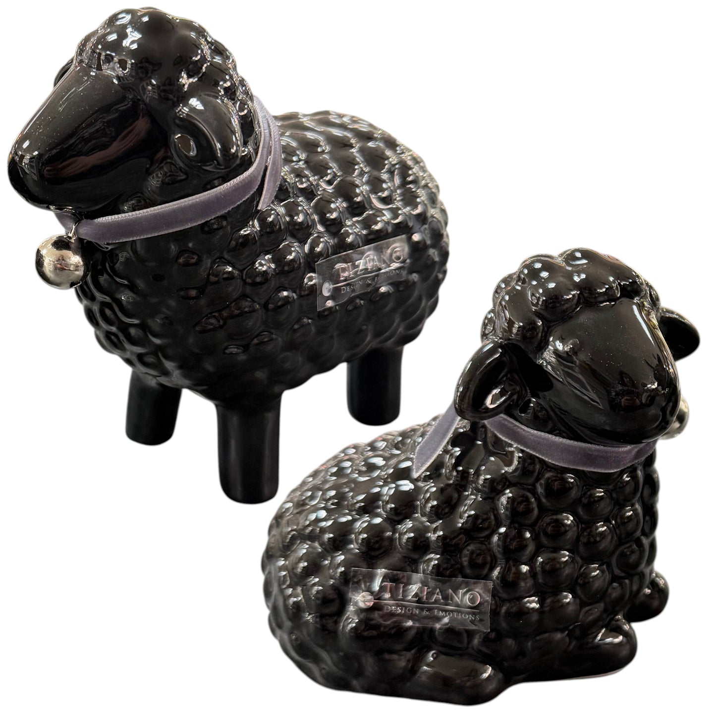 Schwarze Keramik-Schaffiguren liegend und stehend mit Halsband auf weißem Hintergrund