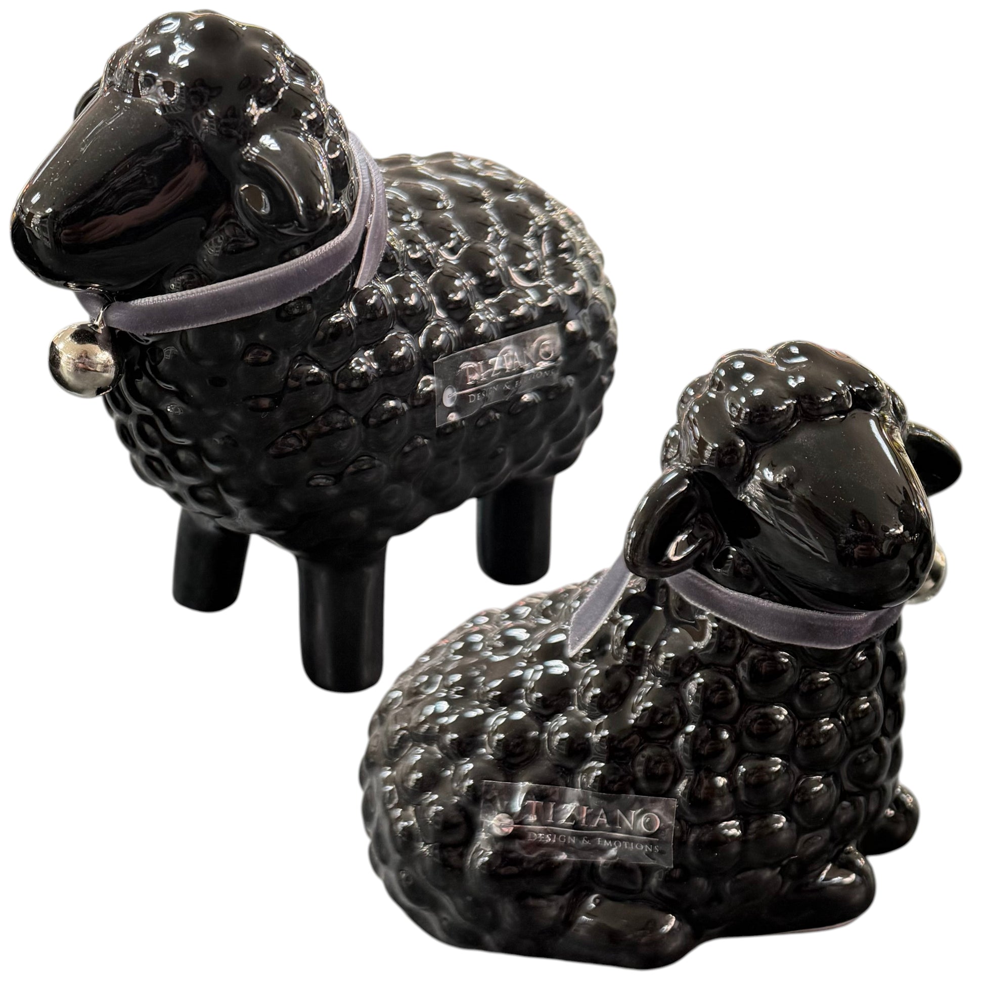 Schwarze Keramik-Schaffiguren liegend und stehend mit Halsband auf weißem Hintergrund