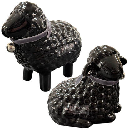 Schwarze Keramik-Schaffiguren liegend und stehend mit Halsband auf weißem Hintergrund