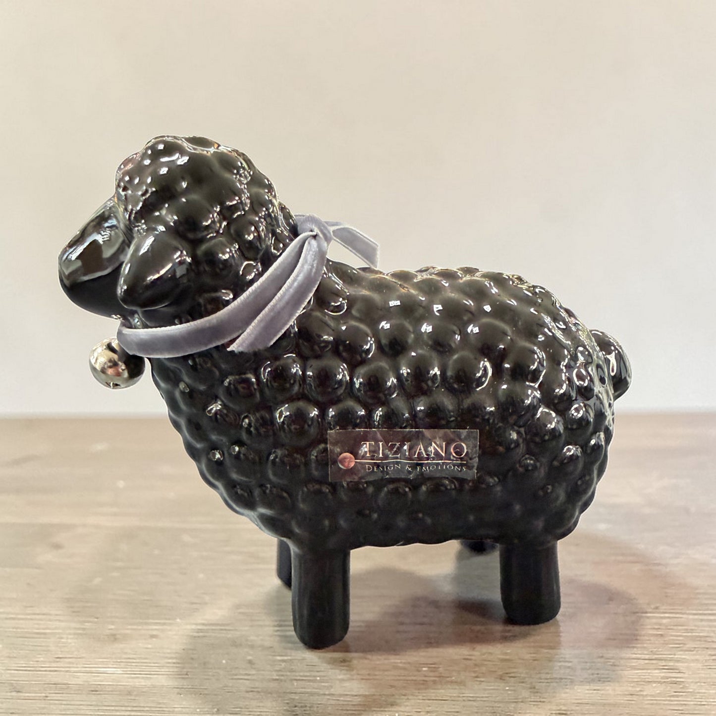 Schwarze Keramik-Schaffigur stehend mit Halsband auf Tisch