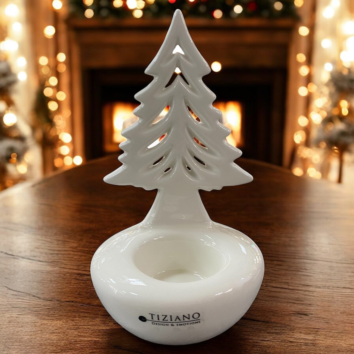 Weißer Keramik-Tannenbaum Joya von Tiziano als Teelichthalter, dekorativ auf Holztisch vor festlicher Beleuchtung.