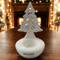 Weißer Keramik-Tannenbaum Joya von Tiziano als Teelichthalter, dekorativ auf Holztisch vor festlicher Beleuchtung.