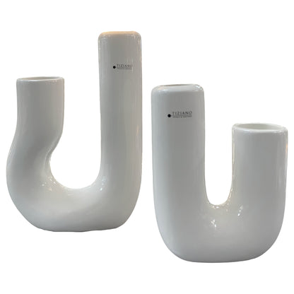 Zwei moderne Keramikvasen in U-Form stehen nebeneinander vor weißem Hintergrund; die linke Vase hat einen weich geschwungenen Verlauf, die rechte eine klare gerade Form.