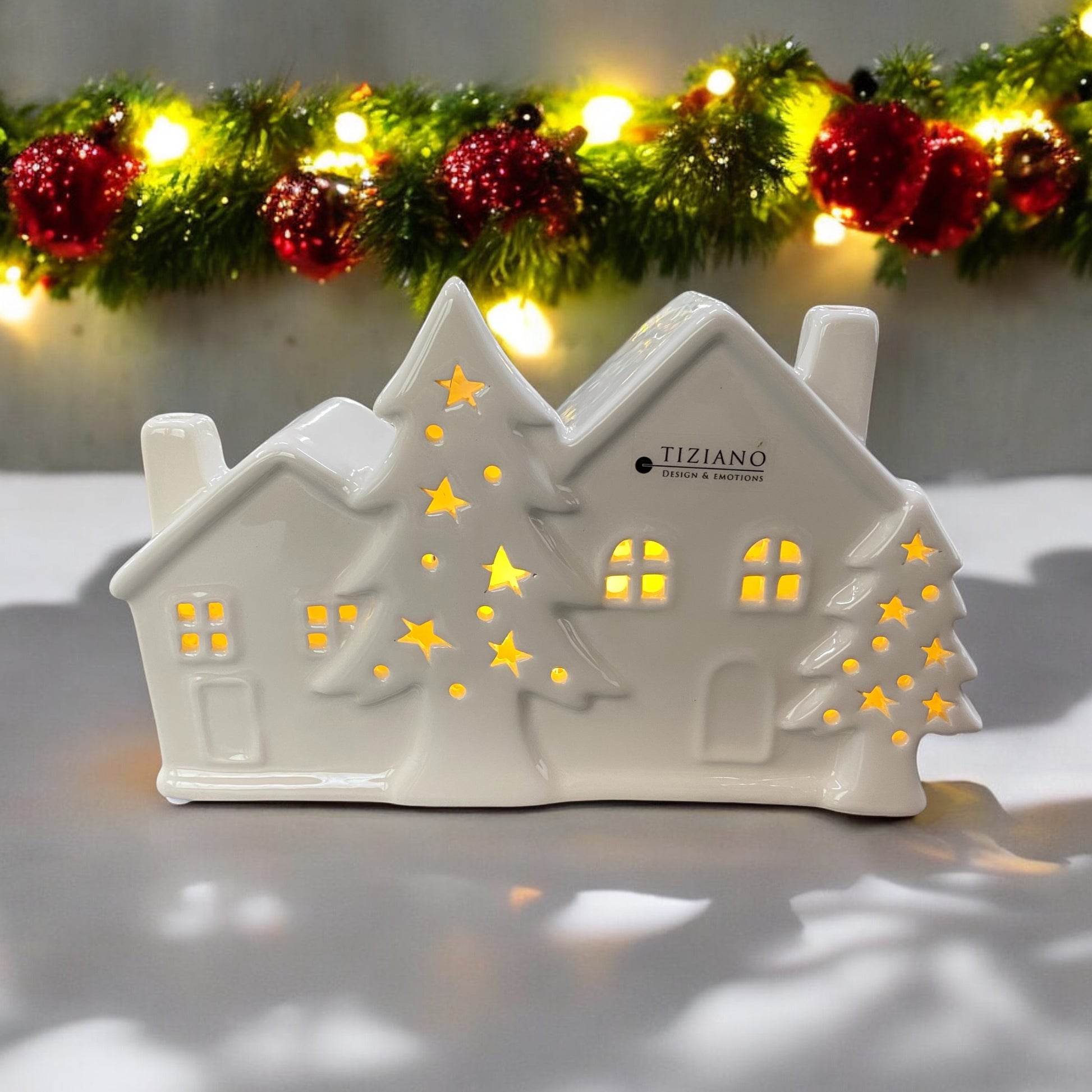 Beleuchtetes LED Doppelhaus mit Tannenbäumen im Ambiente platziert