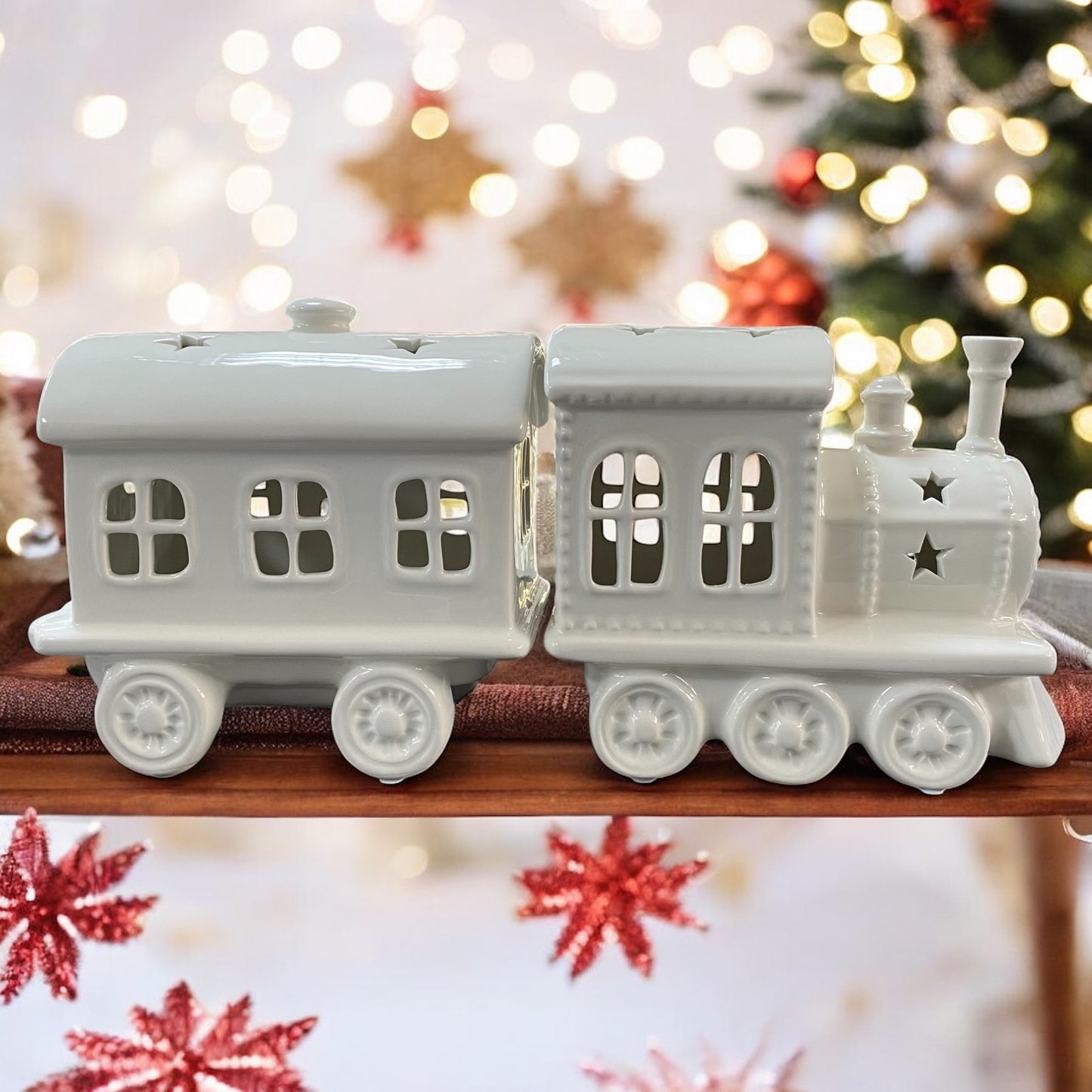 Ein Keramik Weihnachtszug von Tiziano in Creme Weiß mit Stern-Ausschnitten im Ambiente