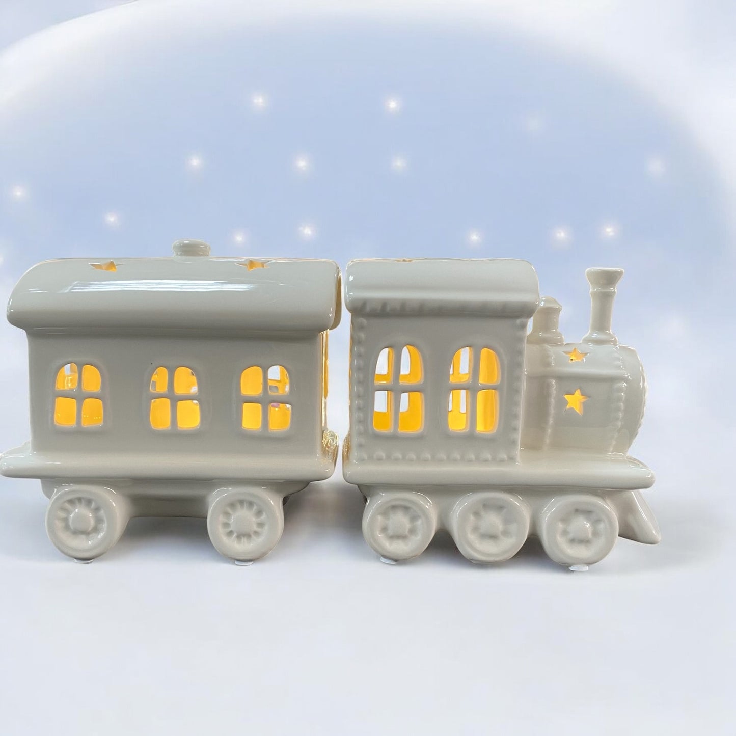 Ein Keramik Weihnachtszug von Tiziano in Creme Weiß mit Stern-Ausschnitten und integrierter LED Beleuchtung im Ambiente