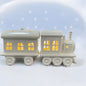 Ein Keramik Weihnachtszug von Tiziano in Creme Weiß mit Stern-Ausschnitten und integrierter LED Beleuchtung im Ambiente