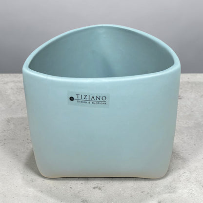 Großes Tiziano Pflanzgefäß in Laguna Blau mit abgerundeter rechteckiger Form und leicht geschwungener Öffnung auf grauem Untergrund.