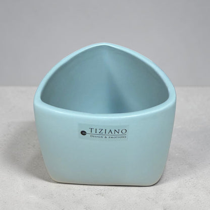 Kleines Tiziano Pflanzgefäß in Laguna Blau mit leicht geschwungener Öffnung auf grauem Untergrund.