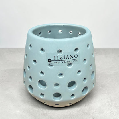 Kleines Tiziano Teelicht Rodano in Laguna Blau mit unterschiedlich großen runden Aussparungen vor grauem Hintergrund.
