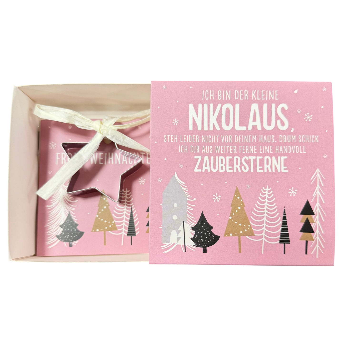 Offene Schachtel mit pinker Karte mit Aufschrift „Nikolaus“ und daran befestigter sternförmiger Ausstechform liegt vor weißem Hintergrund.