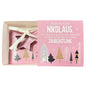 Offene Schachtel mit pinker Karte mit Aufschrift „Nikolaus“ und daran befestigter sternförmiger Ausstechform liegt vor weißem Hintergrund.